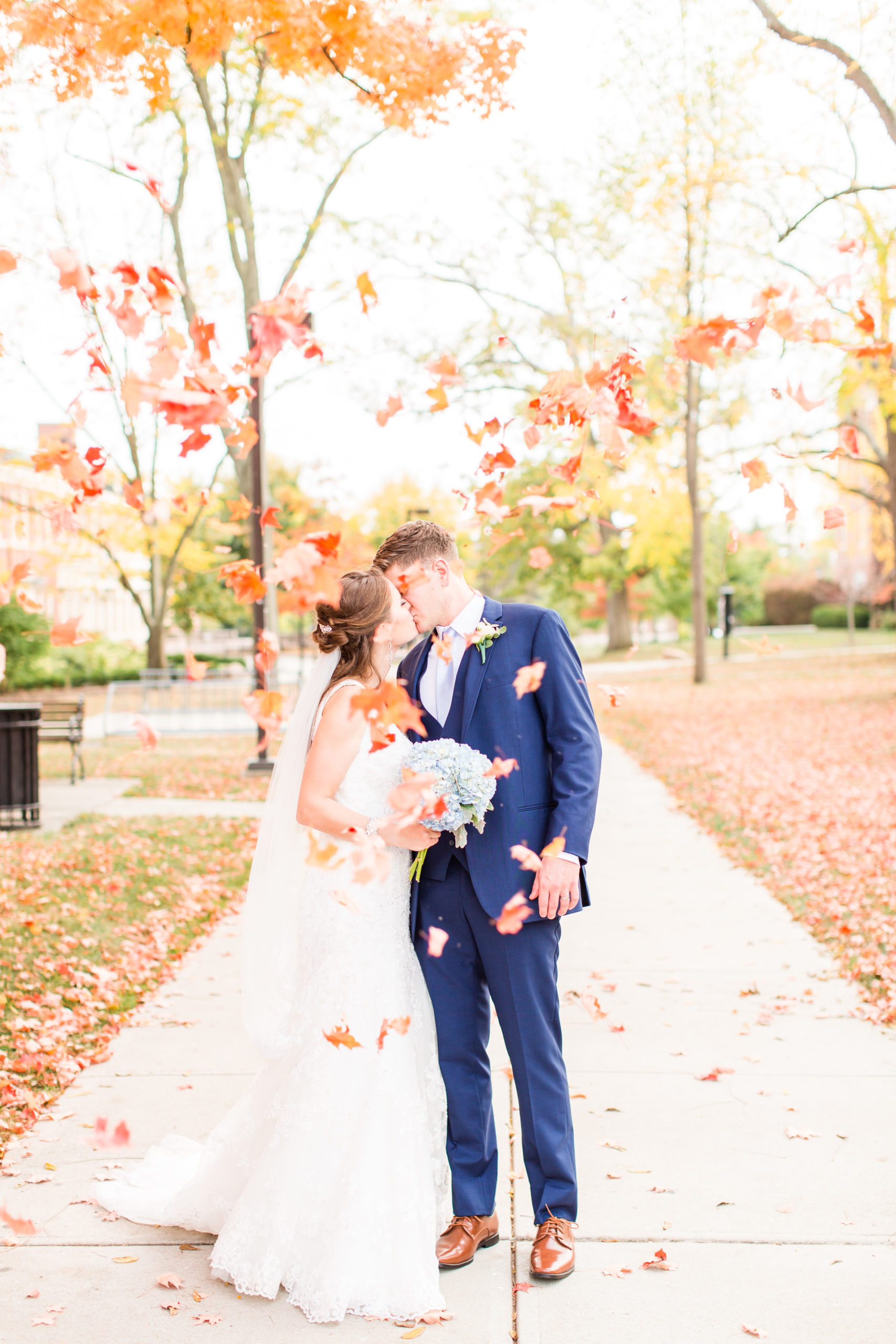 couple kissing in the fall with leaves falling in oxford ohio at miami university